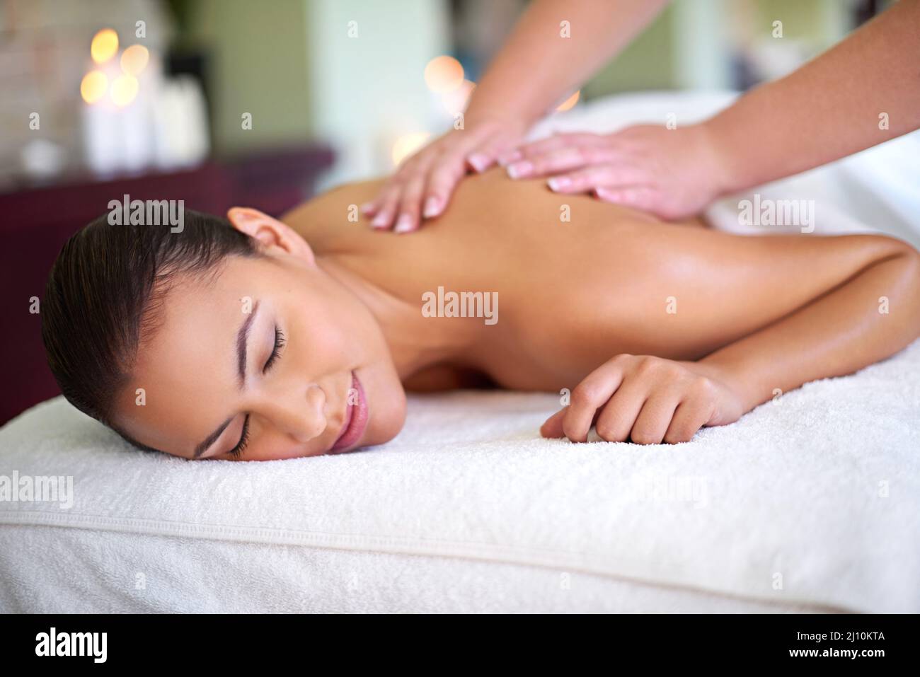Fall into a relaxed, rejuvenated new you. Shot of a young woman enjoying a back massage at a spa. Stock Photo