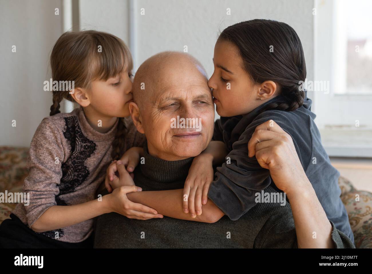 Ukrainian grandfather and two granddaughters hugging Stock Photo