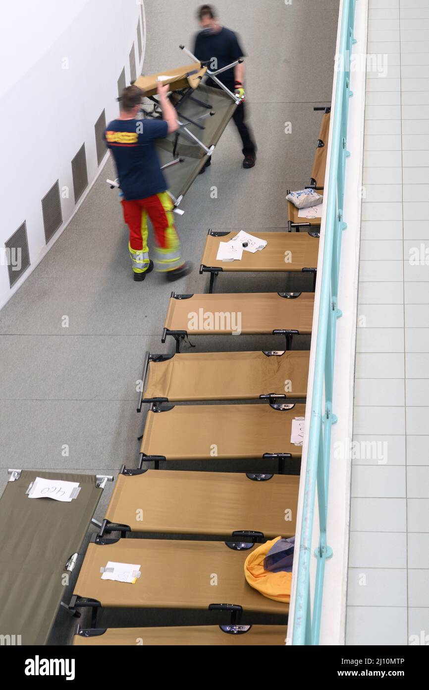 21 March 2022, SaxonyAnhalt, Halle (Saale) Helpers carry cots into