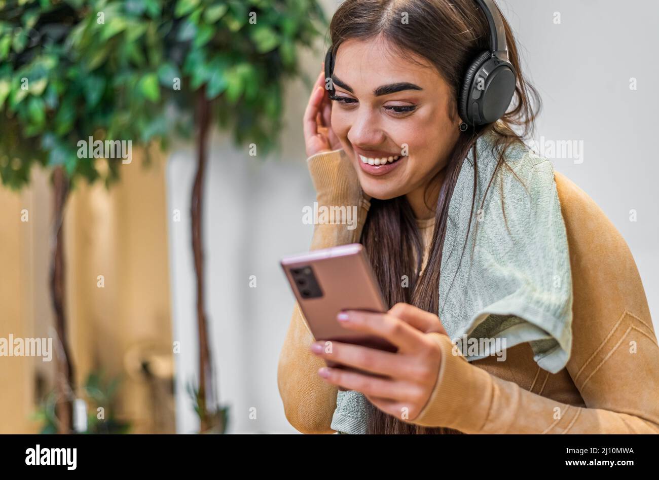 Happy caucasian girl, turning the music on her phone, while using