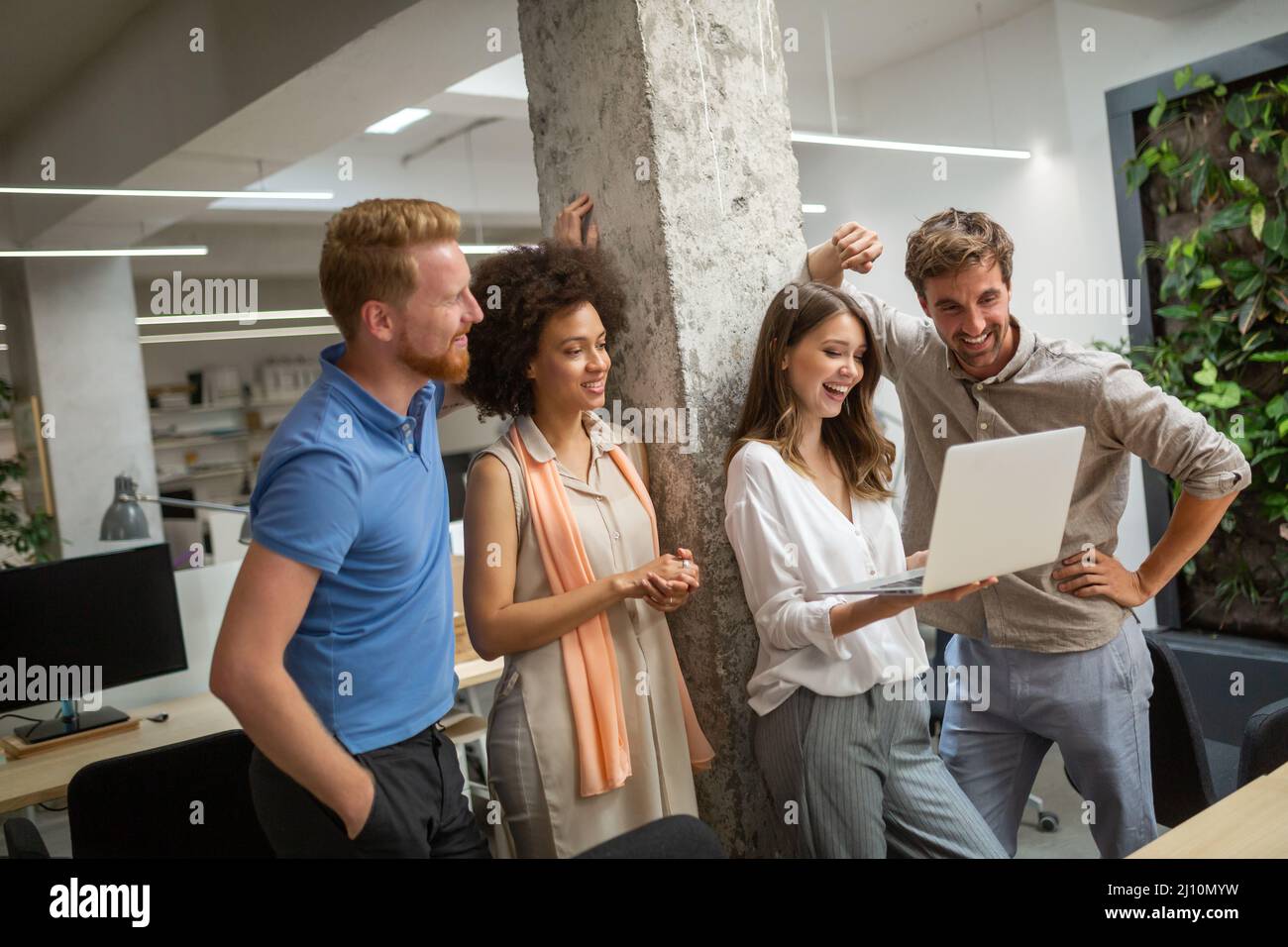 Group of software engineers working developing applications together in corporate office Stock Photo