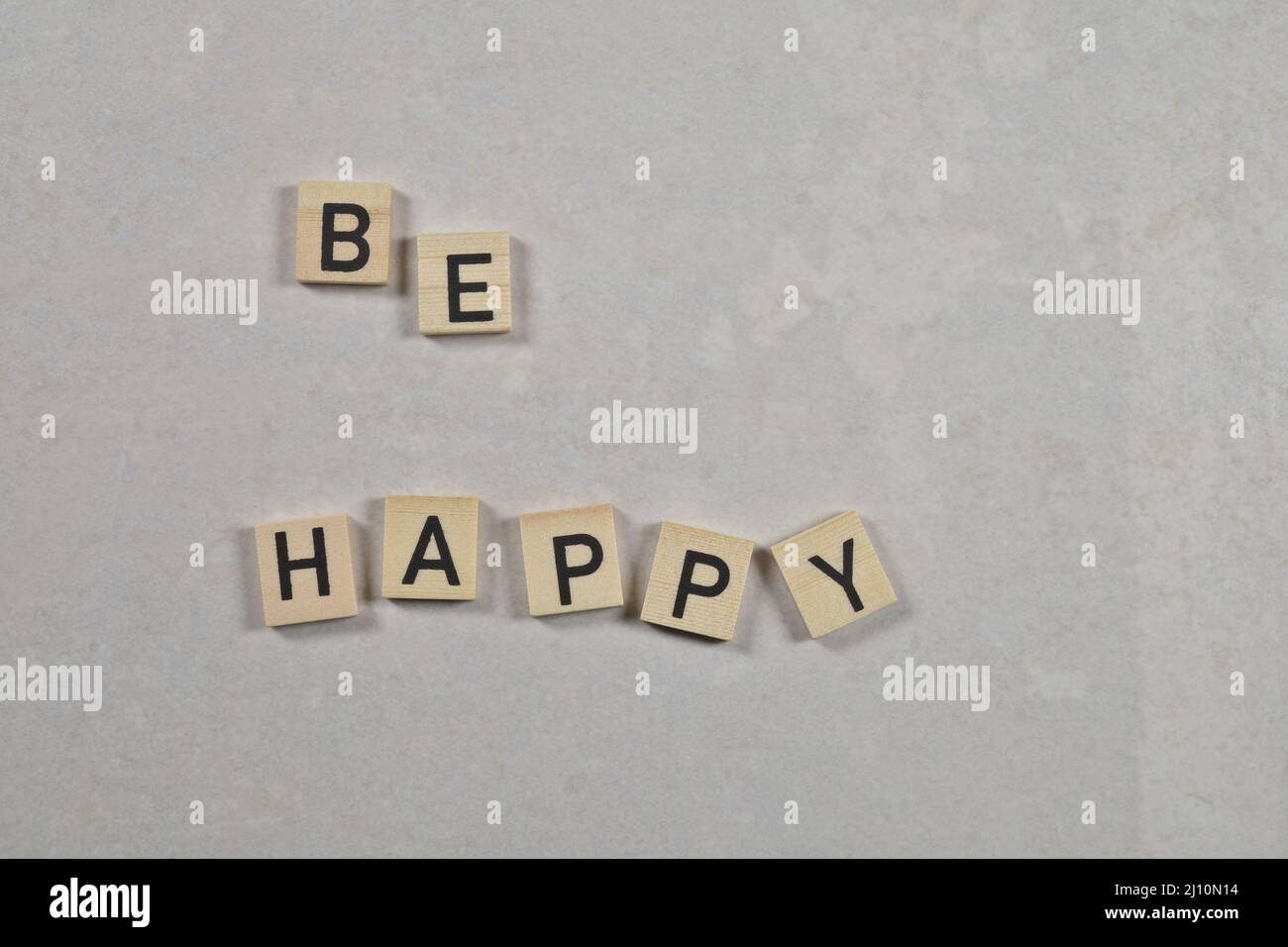 "be happy" phrase on a white ceramic background Stock Photo