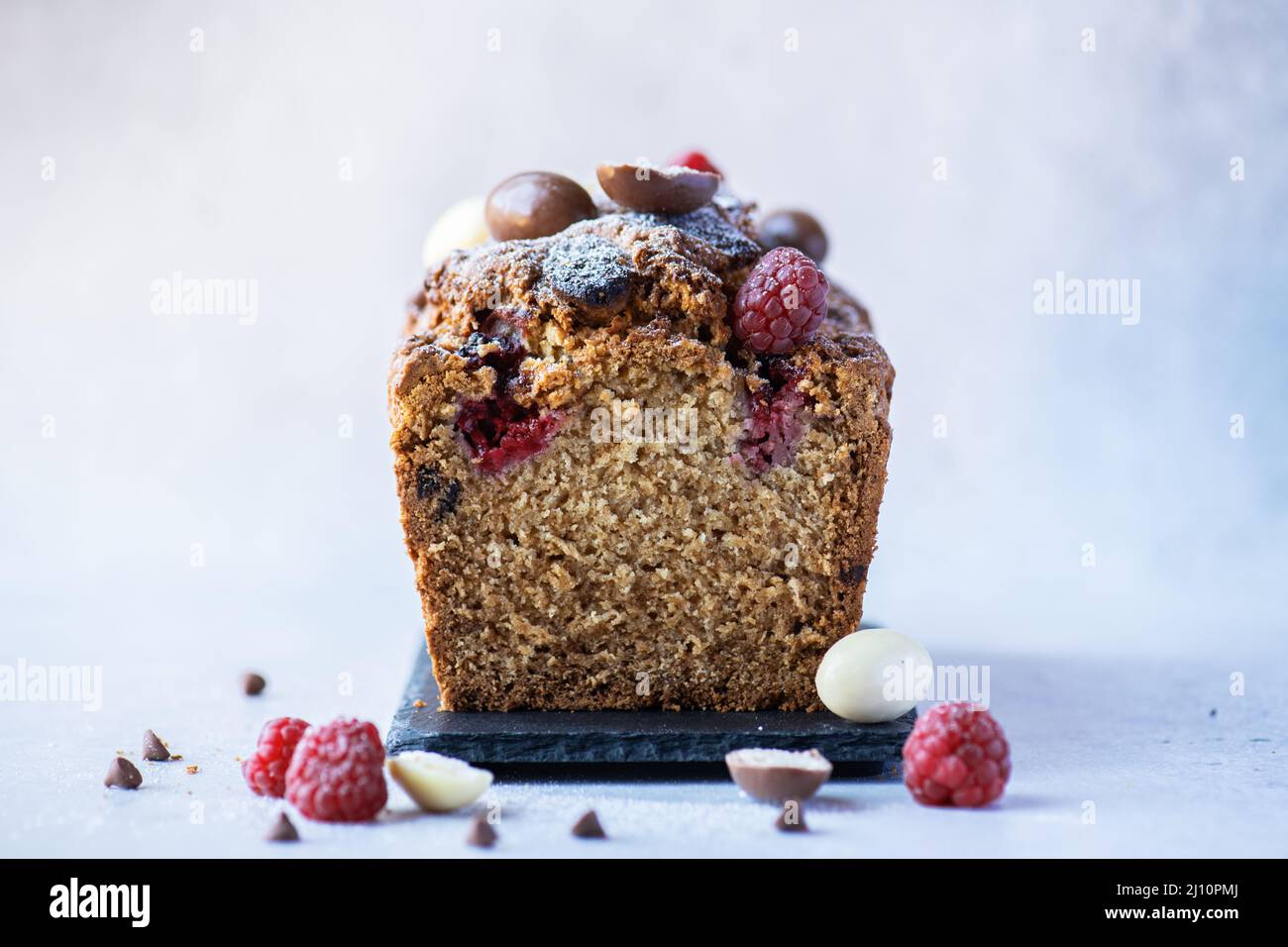 Easter cake with chocolates and raspberry. Sliced. Close up. Stock Photo