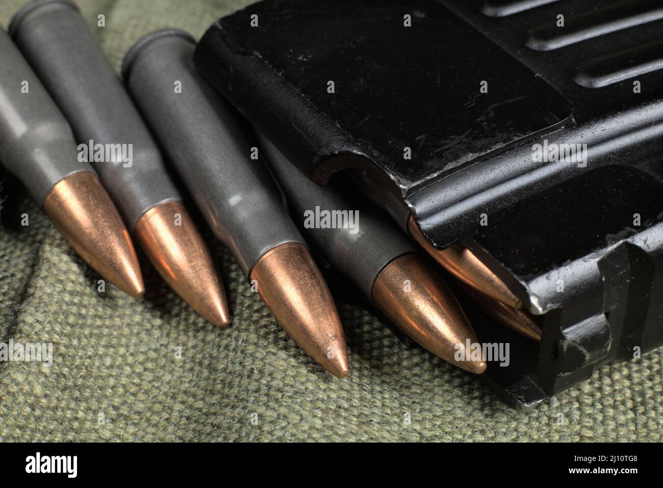 Ak-47 (7,62x39mm) ammunition being loaded to magazine, military canvas background Stock Photo