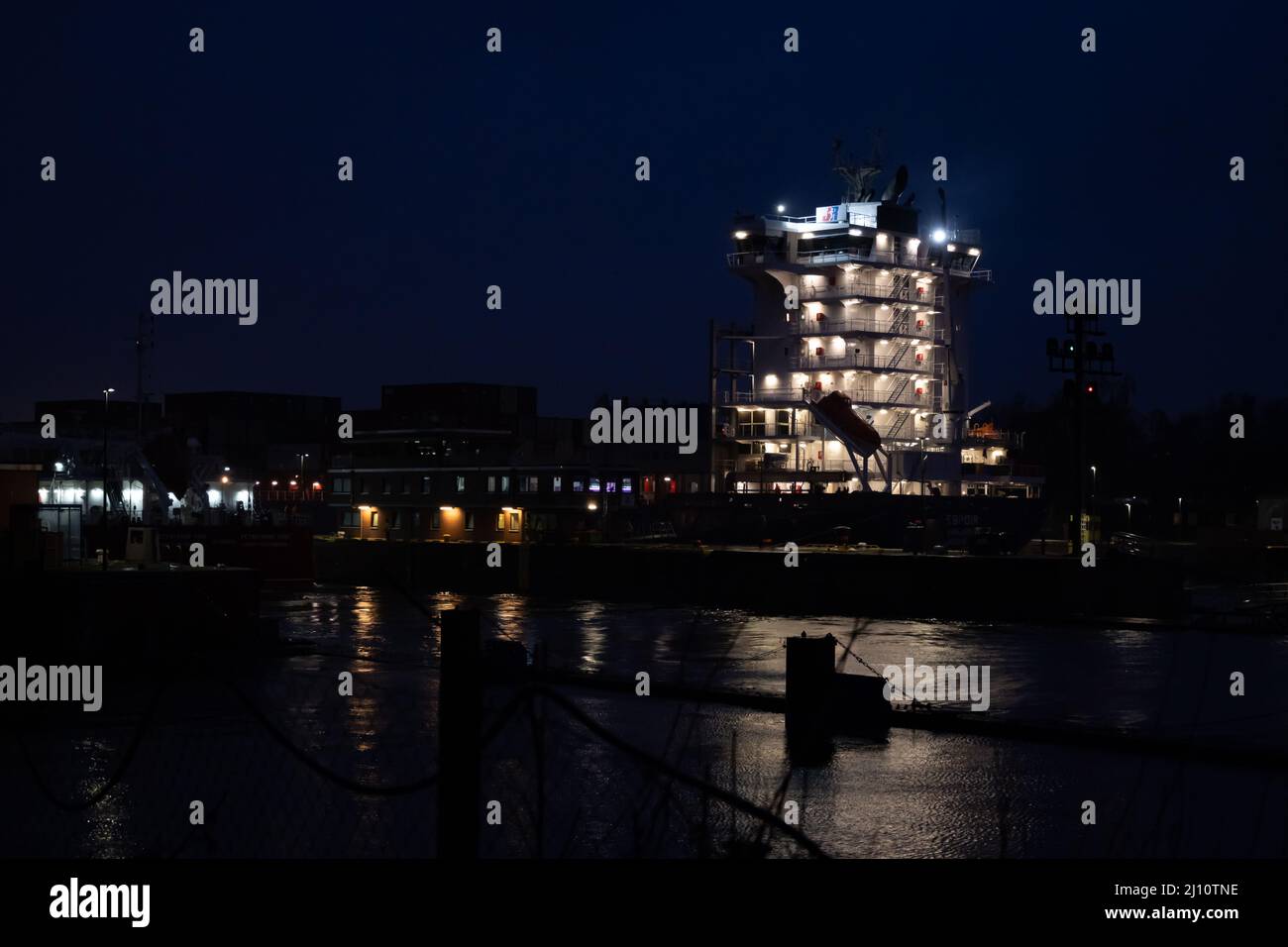 Kiel, Germany - February 22, 2022: A maritime vessel in nighttime is entering the Kiel Canal from the Baltic Sea. The Kiel Canal links the Baltic Sea with the North Sea Stock Photo