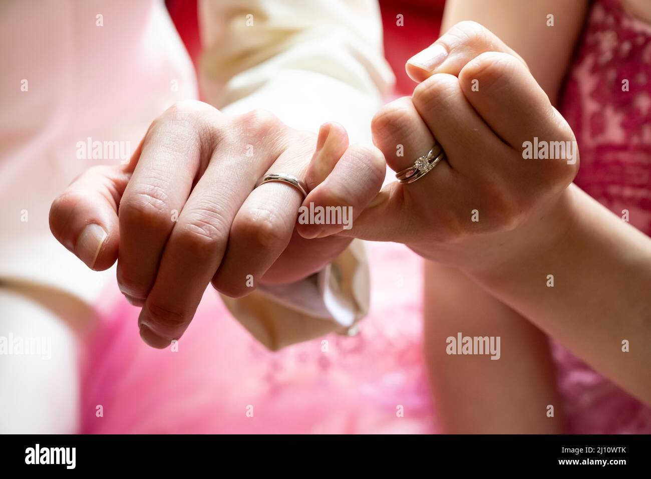 Left hands of men and women tied with a tight bond Stock Photo
