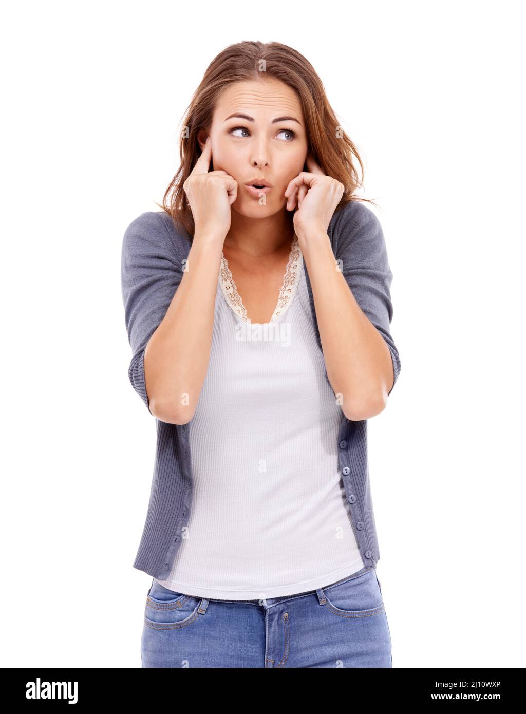 Wow, thats loud. Casually dressed woman blocking her ears - isolated on white. Stock Photo