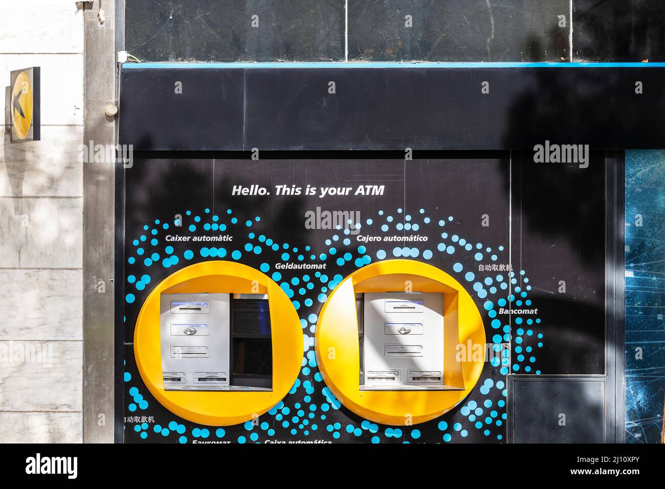 Barcelona, Spain - February 24, 2022: ATM Cash Machine of Caixabank in several languages in Barcelona, Catalonia, Spain Stock Photo