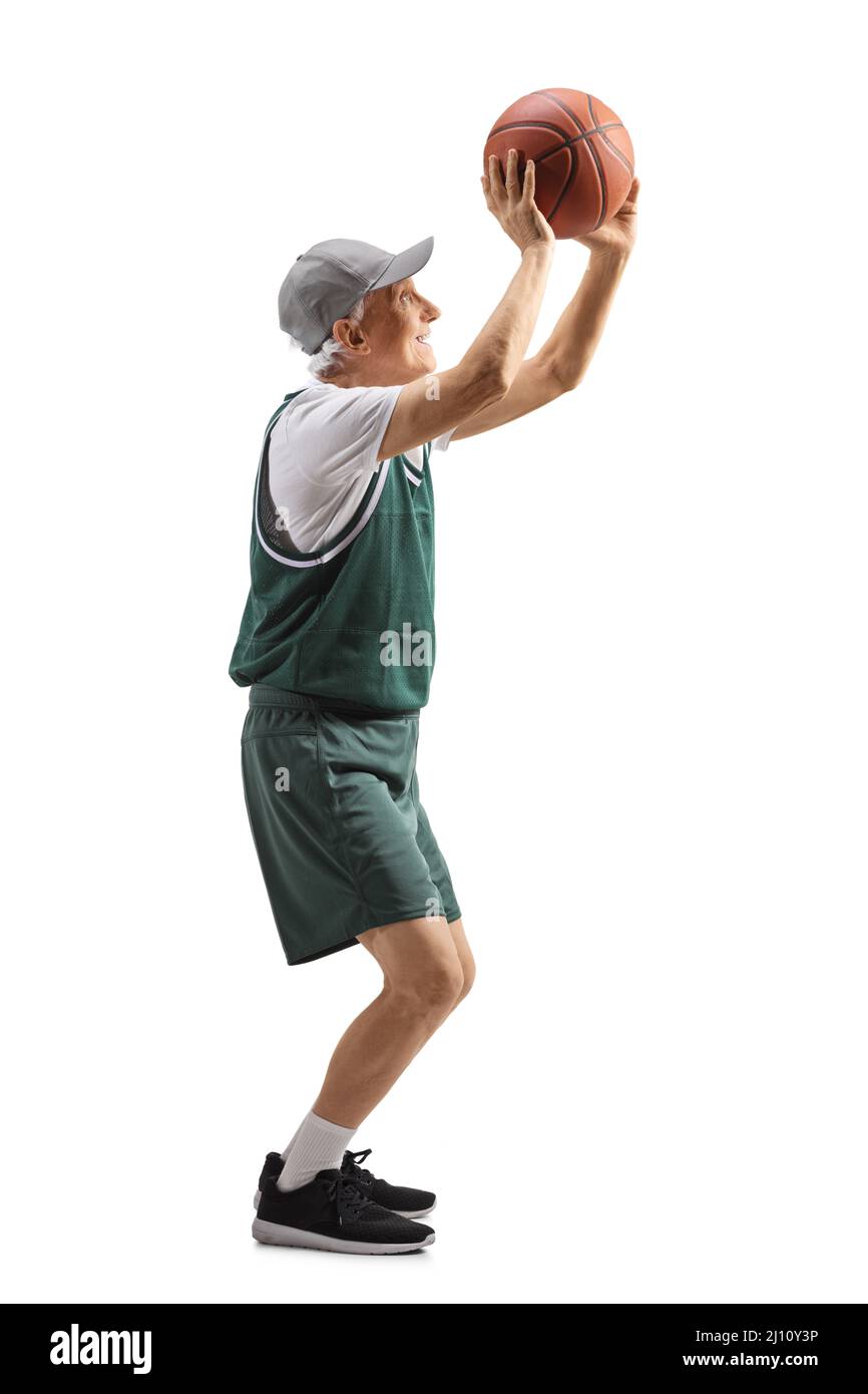 Full length profile shot of an elderly man shooting a basketball isolated on white background Stock Photo