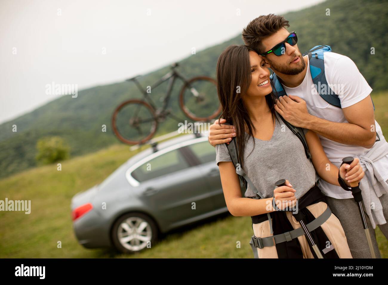 Couple of young hikers with backpacks starting a walk through the