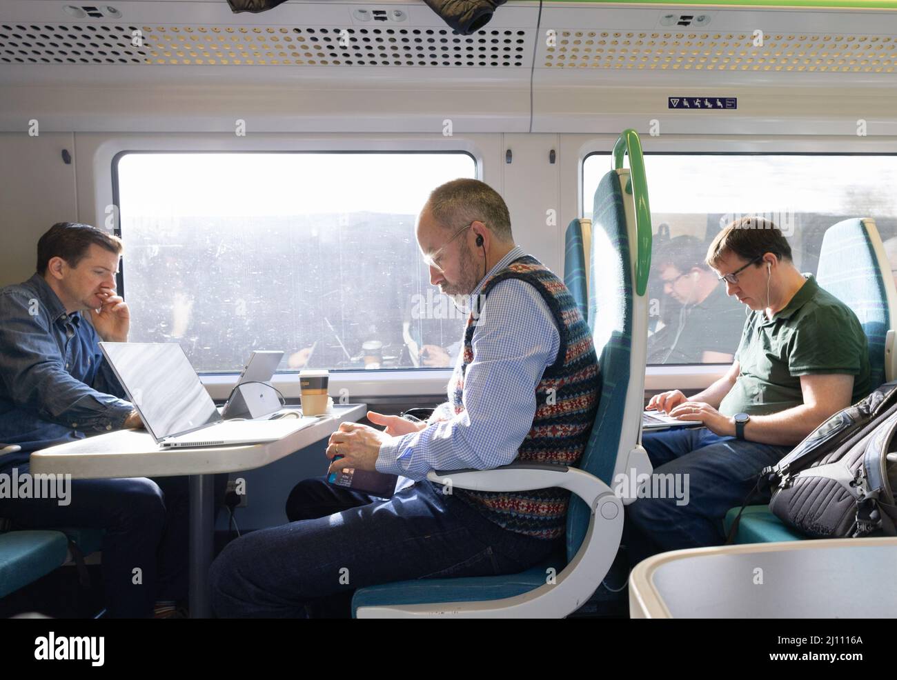Train passengers UK; Railway commuters working with computers on the