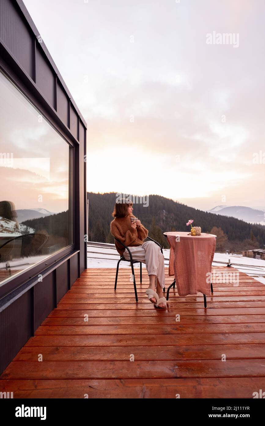 Woman resting at small house in the mountains Stock Photo - Alamy