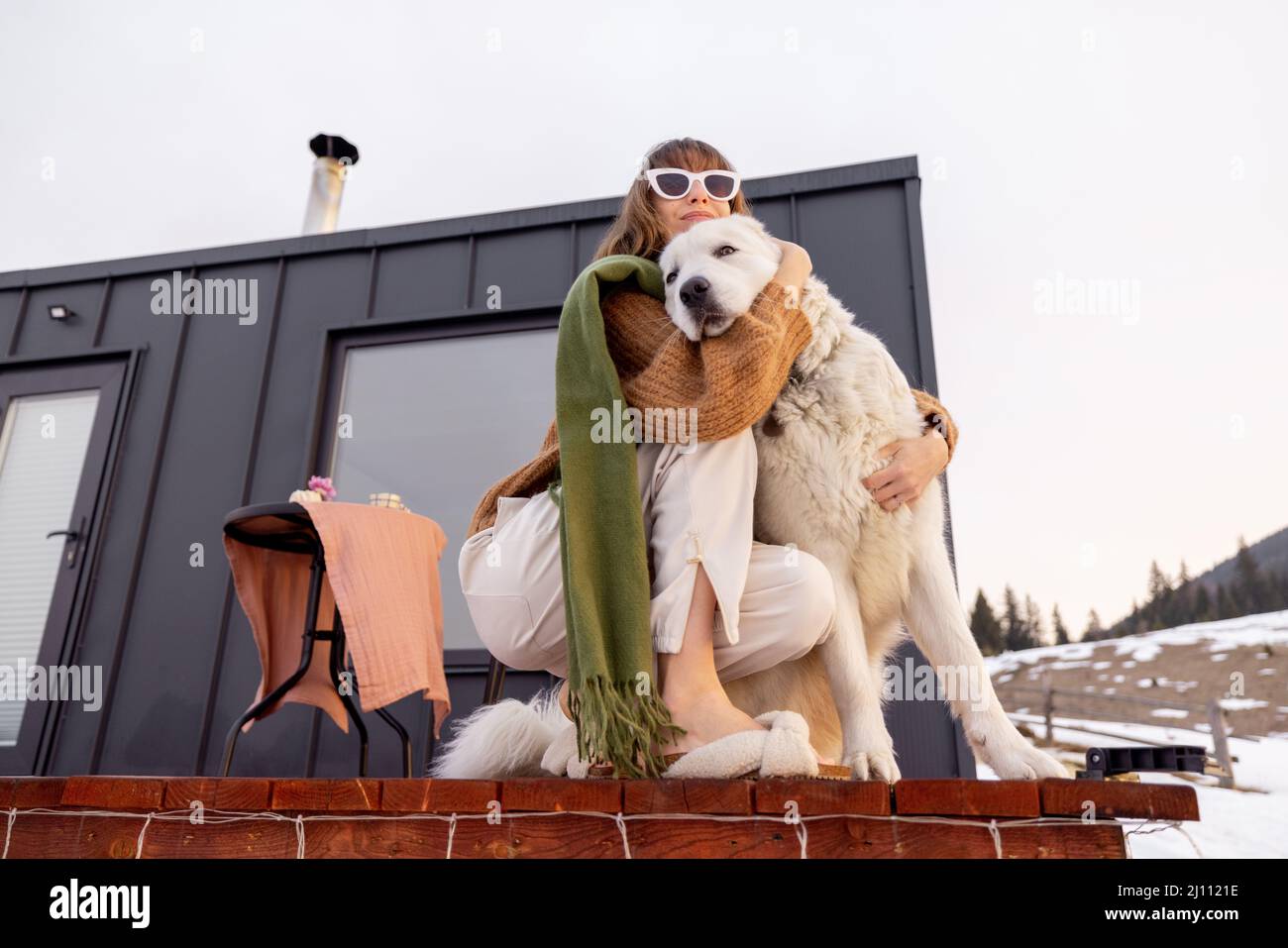 Woman with her dog resting on terrace of tiny house on nature Stock ...