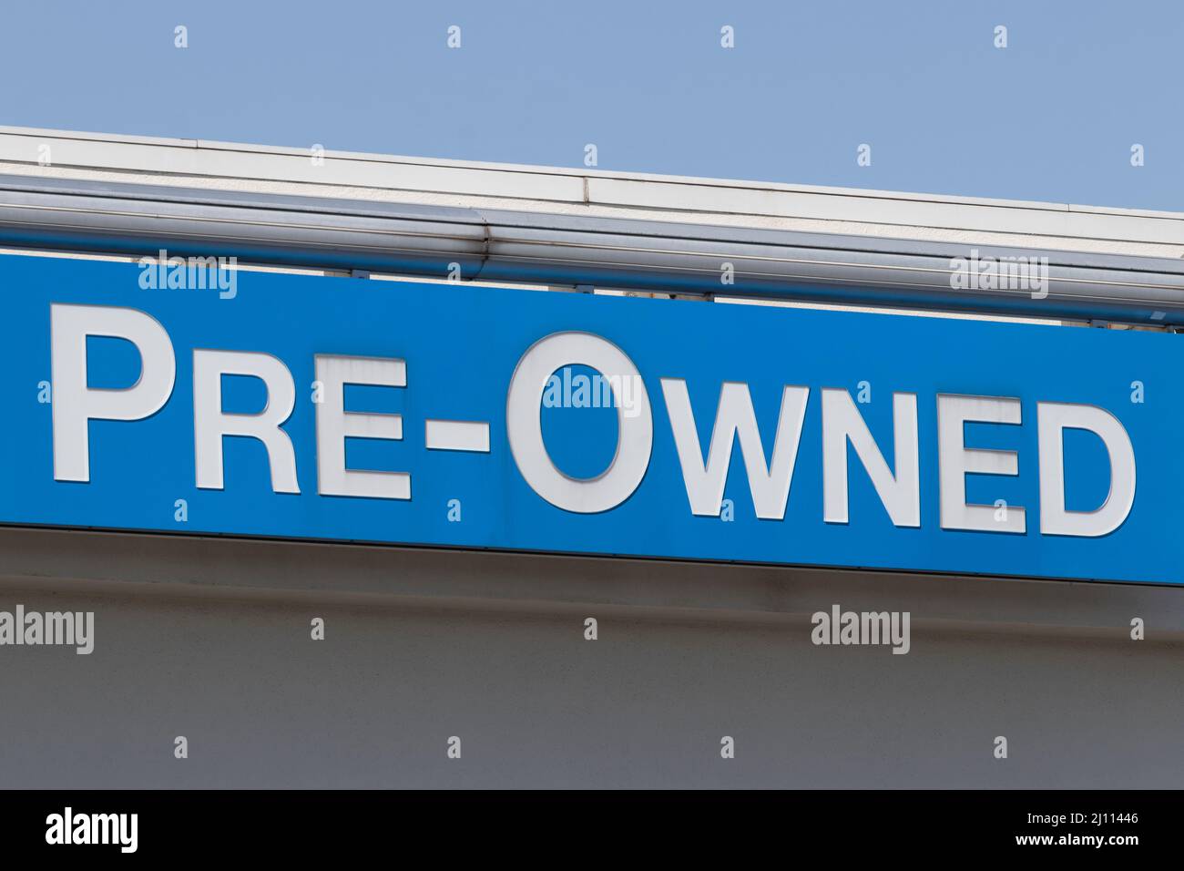 Pre-Owned Cars sign at a used car dealership. As supplies of new cars dwindle, used cars become more popular. Stock Photo