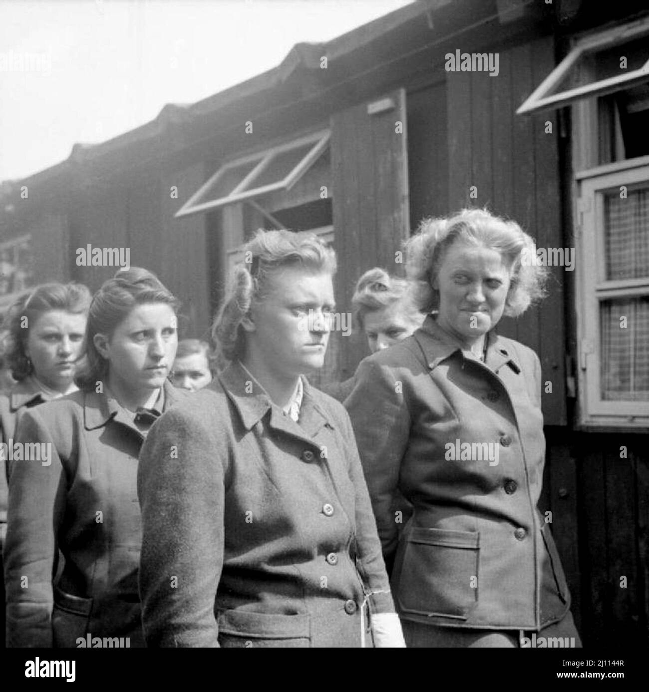 SS women camp guards are paraded for work in clearing the dead. The women include Hildegard Kanbach (first from left), Irene Haschke (centre, third from right), the Head Wardress, Elisabeth Volkenrath (second from right, partially hidden) and Herta Bothe (first from right). Herta Bothe accompanied a death march of women from central Poland to Bergen-Belsen. She was sentenced to 10 years imprisonment and released early from prison on December 22, 1951. Elisabeth Volkenrath was head wardress of the camp and sentenced to death. She was hanged on December 13 1945. Irene Haschke was sentenced to 10 Stock Photo