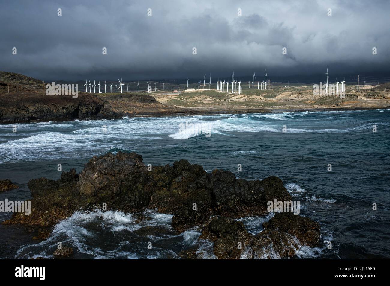 Windfarm turbines seen across the bay of Playa Grande on the east coast at Poris de Abona, Tenerife, Canary Islands, Spain Stock Photo
