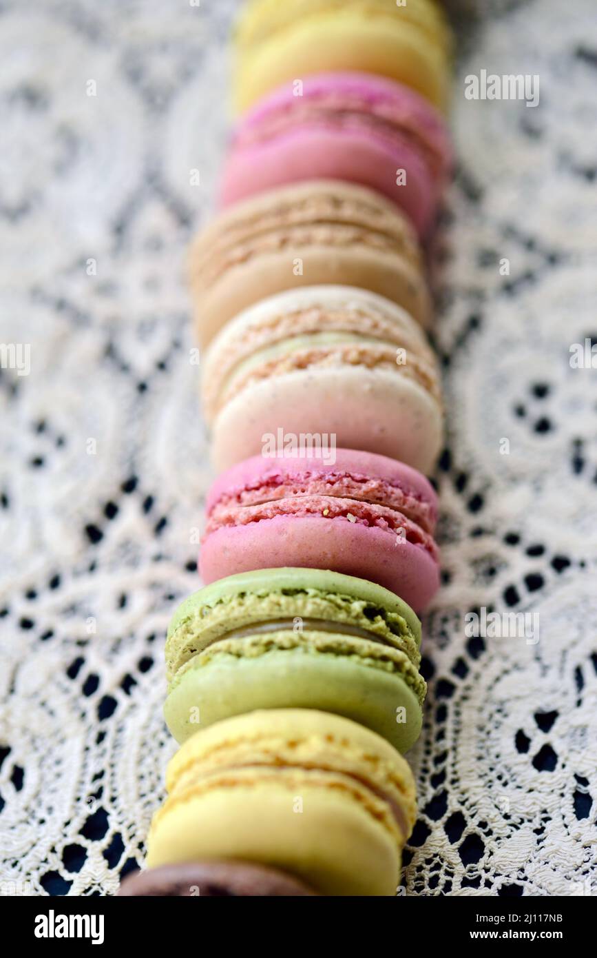 A row of colorful pastel french macaron cookies on a vintage lace tablecloth Stock Photo