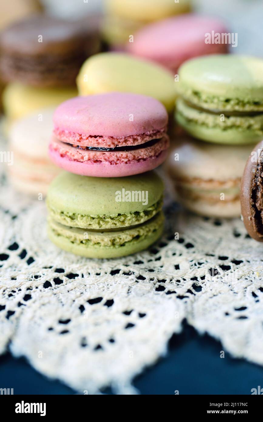 Lots of pastel french macaron cookies on a vintage lace tablecloth Stock Photo