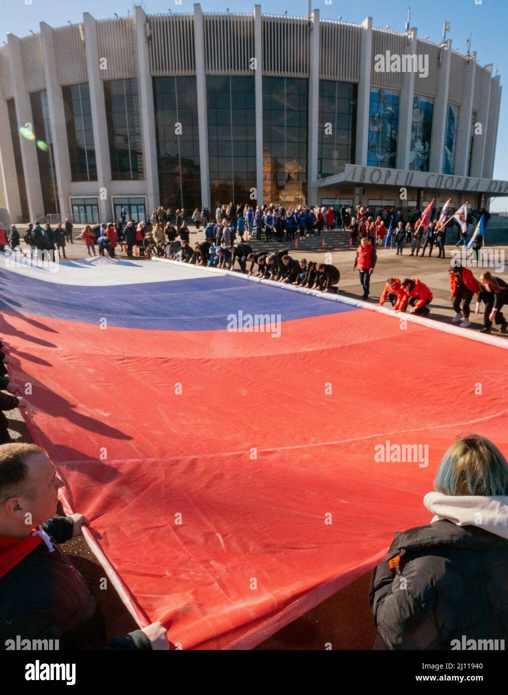 Concert-action dedicated to the eighth anniversary of the reunification of the Crimea with Russia, in the Yubileiny sports complex. Genre photography. Participants roll up a canvas with the colors of the Russian flag near the Yubileiny sports complex. 18.03.2022 Russia, St. Petersburg Photo credit: Aleksey Smagin/Kommersant/Sipa USA Stock Photo