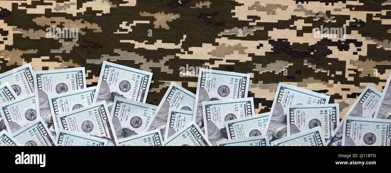 US dollar bills on fabric with texture of Ukrainian military pixeled ...