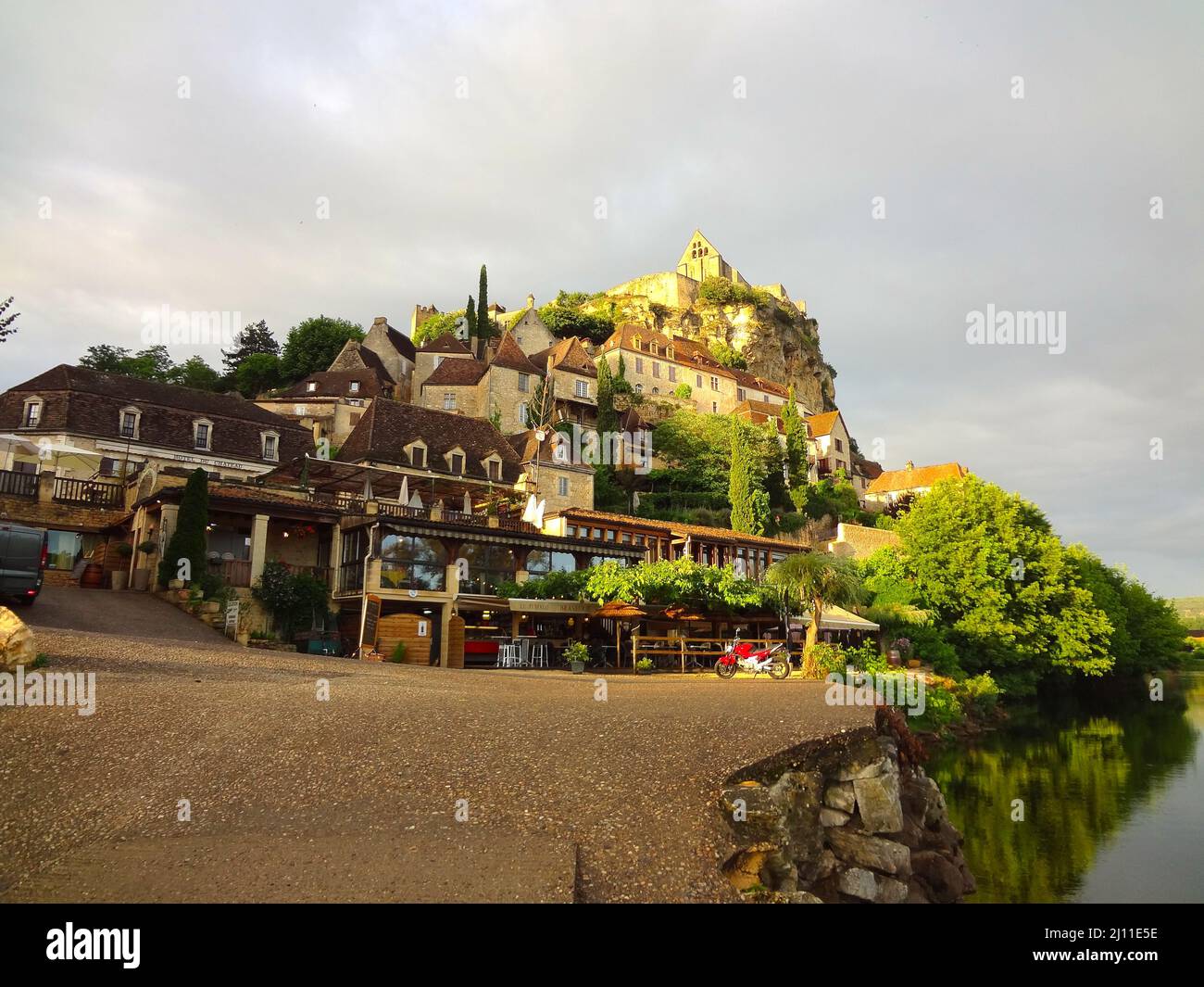 Shot of buildings with trees by the sea Stock Photo - Alamy