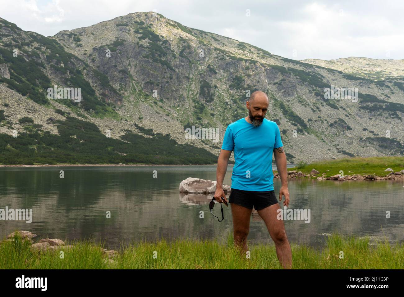 Hiking guide telling a story about the Smradlivoto or Stinky Lake in Rila National Park and Nature Reserve, Bulgaria, Balkans. Stock Photo