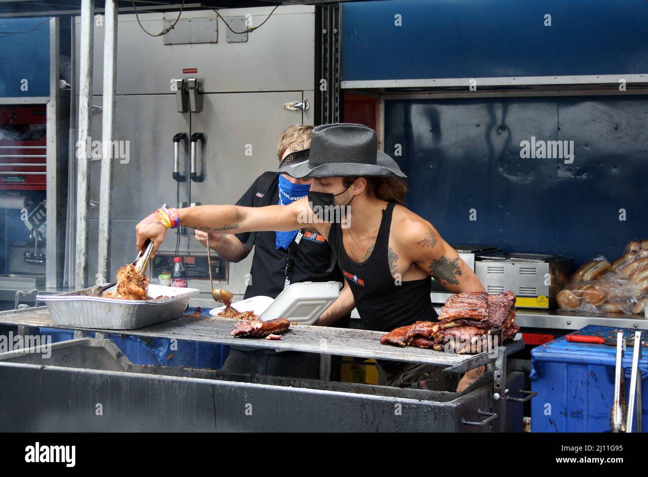 Man in cowboy hat grilling pork ribs at PNE (Pacific National