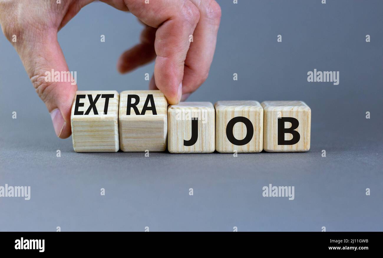 Extra job symbol. Businessman turns wooden cubes and changes concept ...