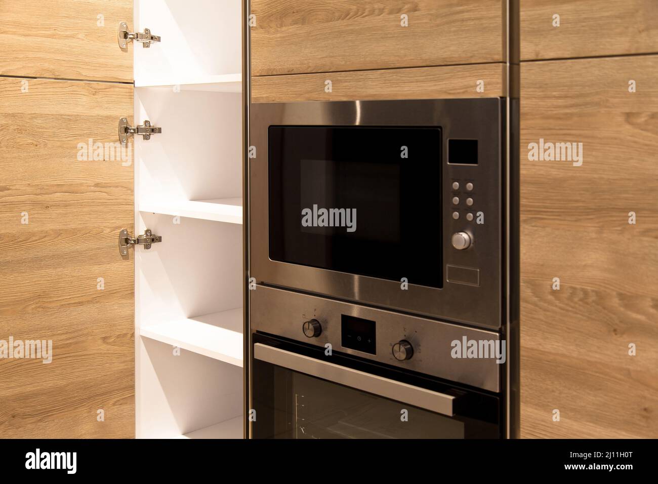 Interior of luxurious modern kitchen equipment, white and oak