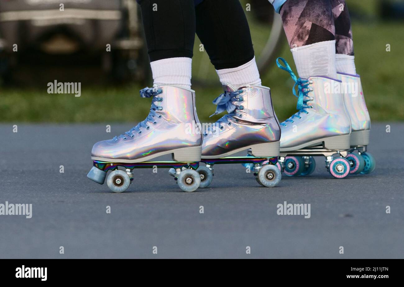 Berlin, Germany. 19th Mar, 2022. 19.03.2022, Berlin. Two women ride on color-changing and iridescent roller skates on Tempelhofer Feld. Credit: Wolfram Steinberg/dpa Credit: Wolfram Steinberg/dpa/Alamy Live News Stock Photo