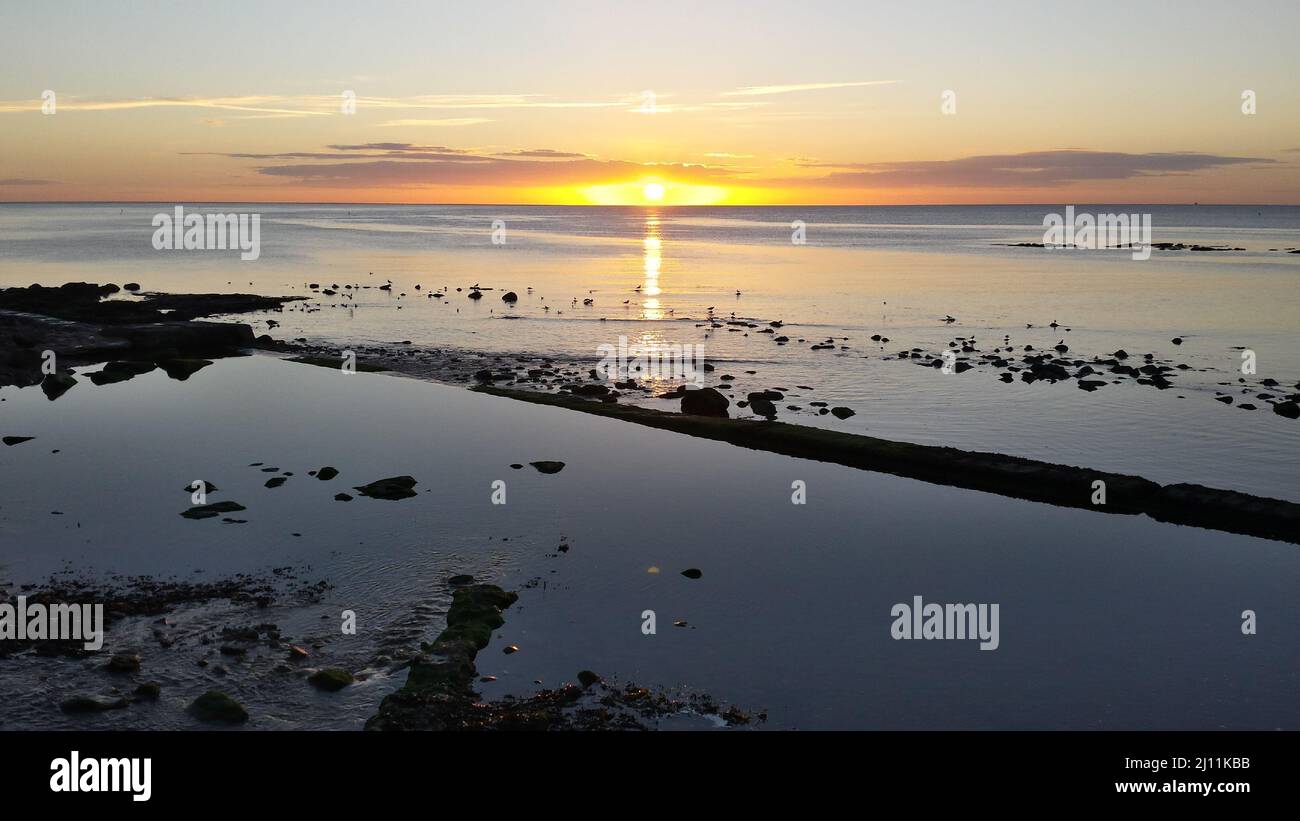 Sunrise Across The North Sea - Scarborough - Orange + Blue Colour -  Early Morning - Calm Sea - Yorkshire UK Stock Photo