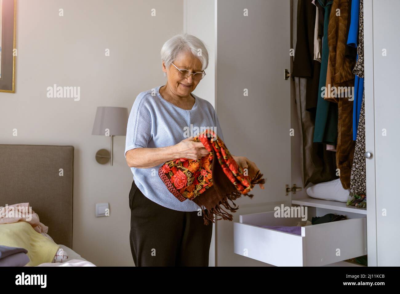 Senior woman sorting out wardrobe Stock Photo