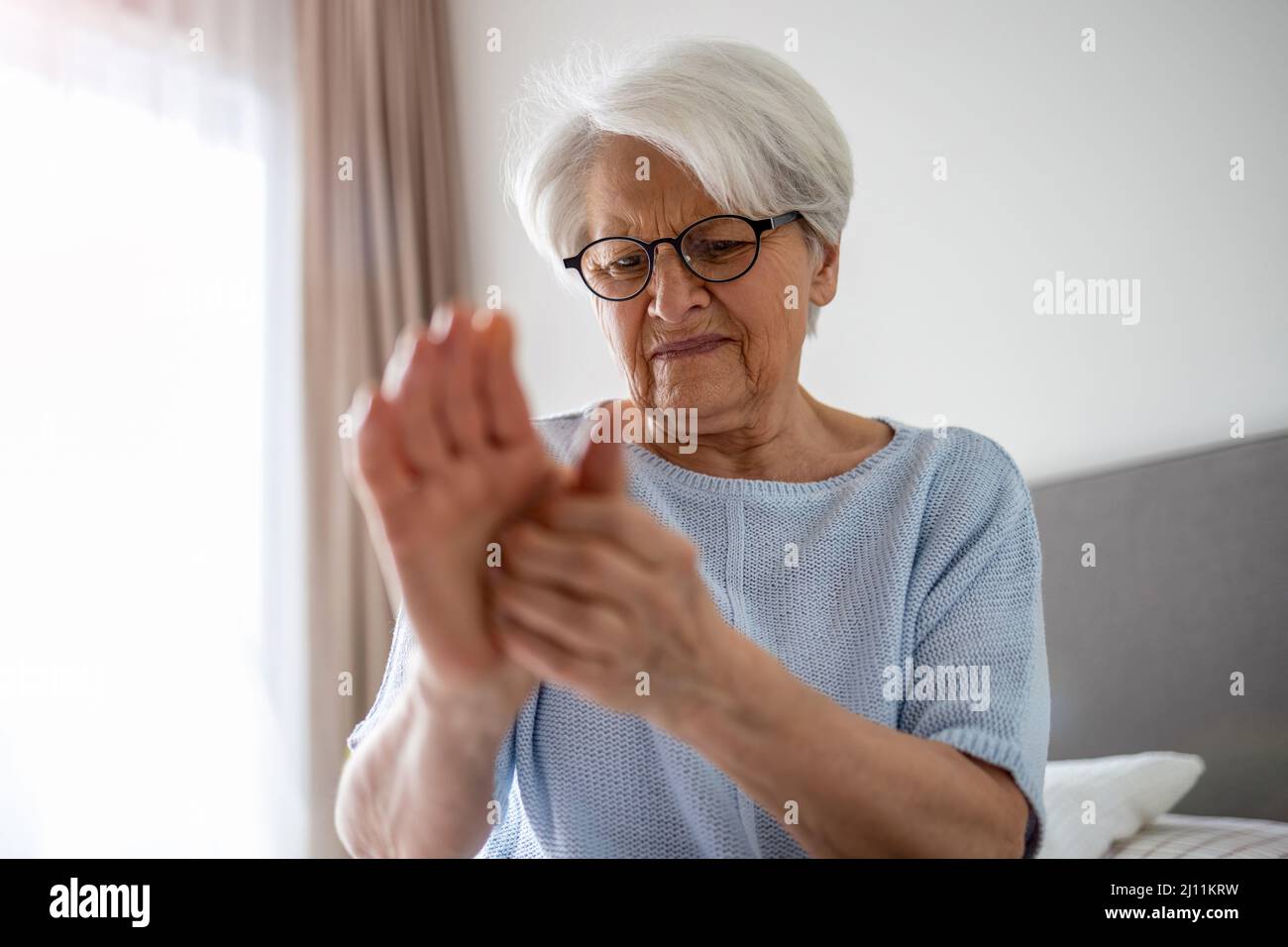 Senior woman with arthritis rubbing hands Stock Photo Alamy