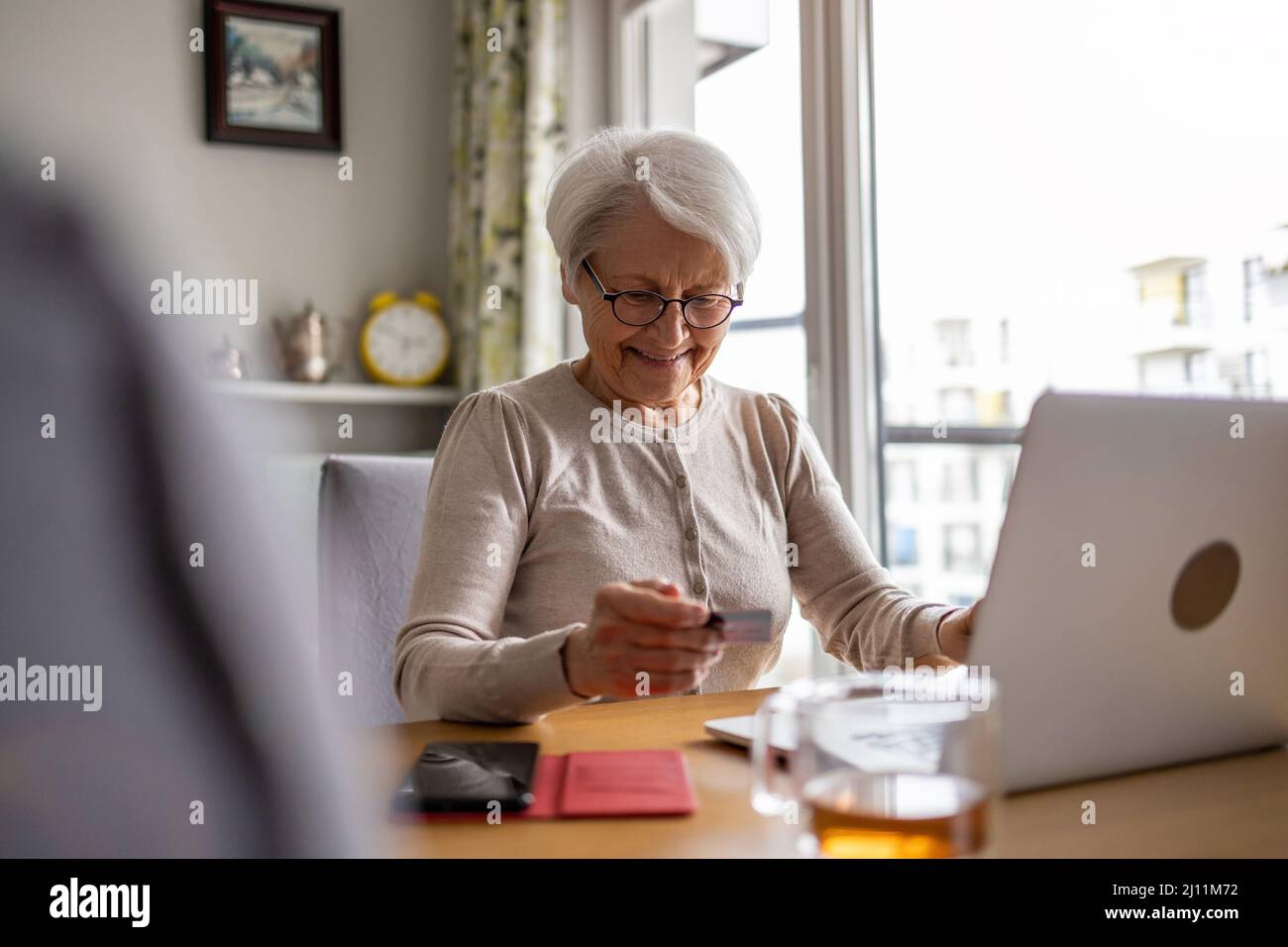 Senior woman doing online shopping on laptop at home Stock Photo