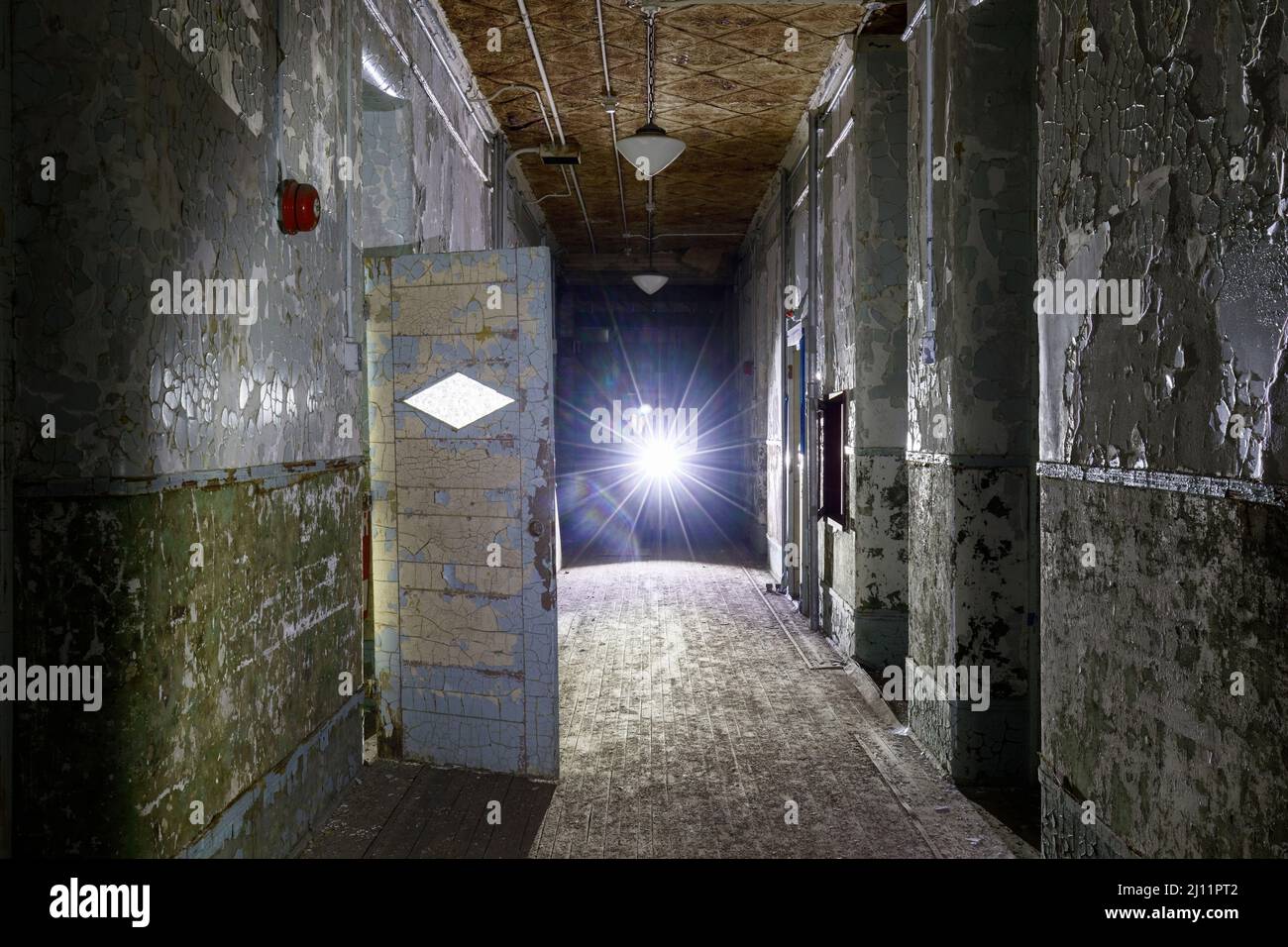 Hallway inside an abandoned asylum with moody lighting. Stock Photo