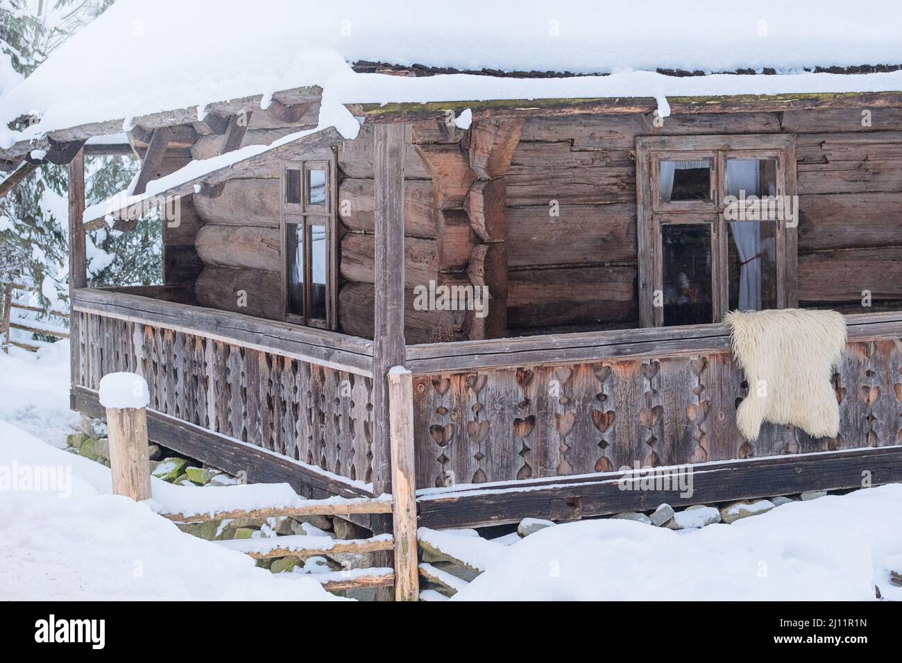 Rural house in village near the forest. Authentic traditional culture in architecture and life. Old wooden buildings in winter. Installation in museum Stock Photo