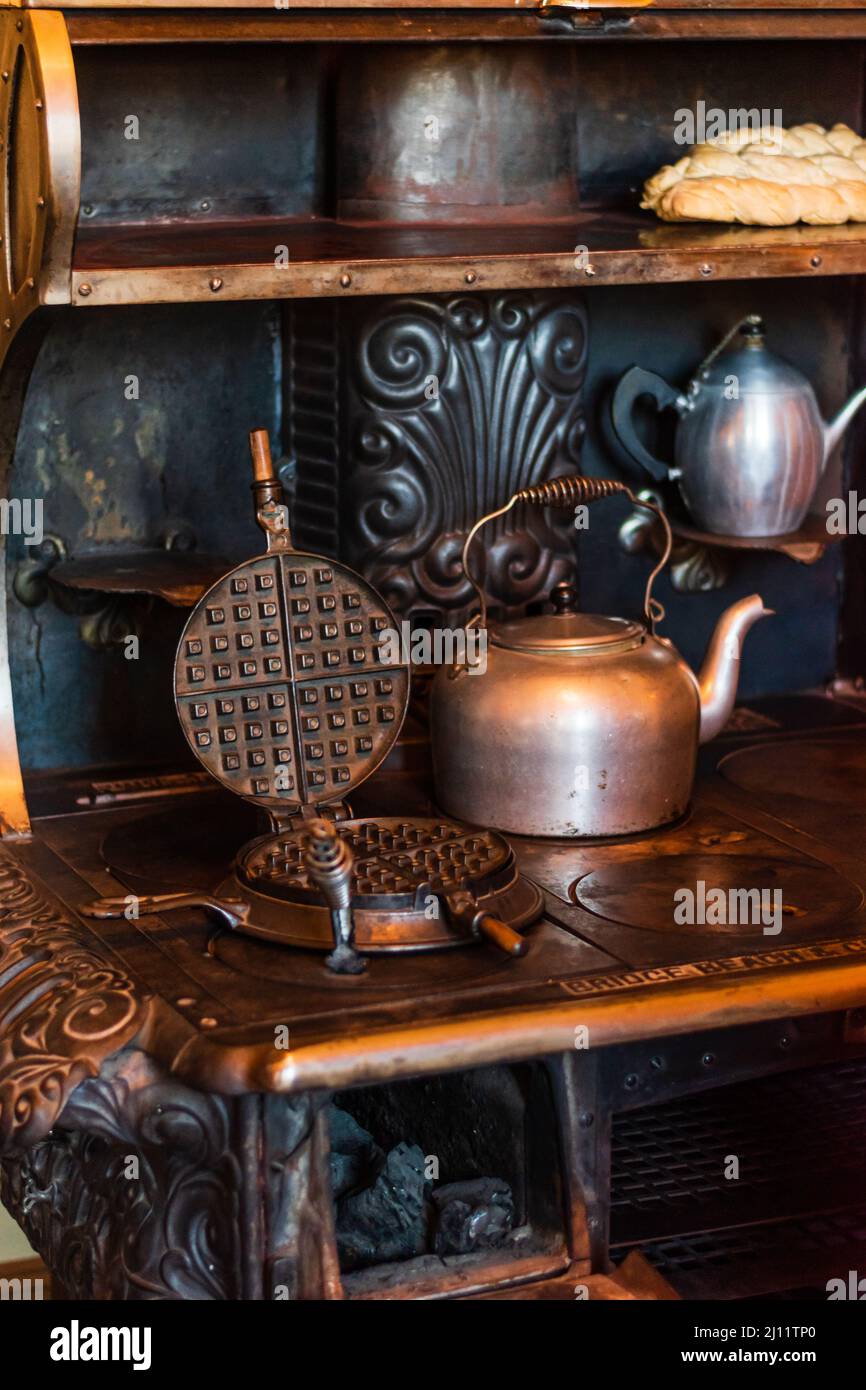 Antique teapot cattle and cast iron waffle maker on cast iron coal stove at the Riordan Mansion in Flagstaff, Arizona, U.S.A. Stock Photo
