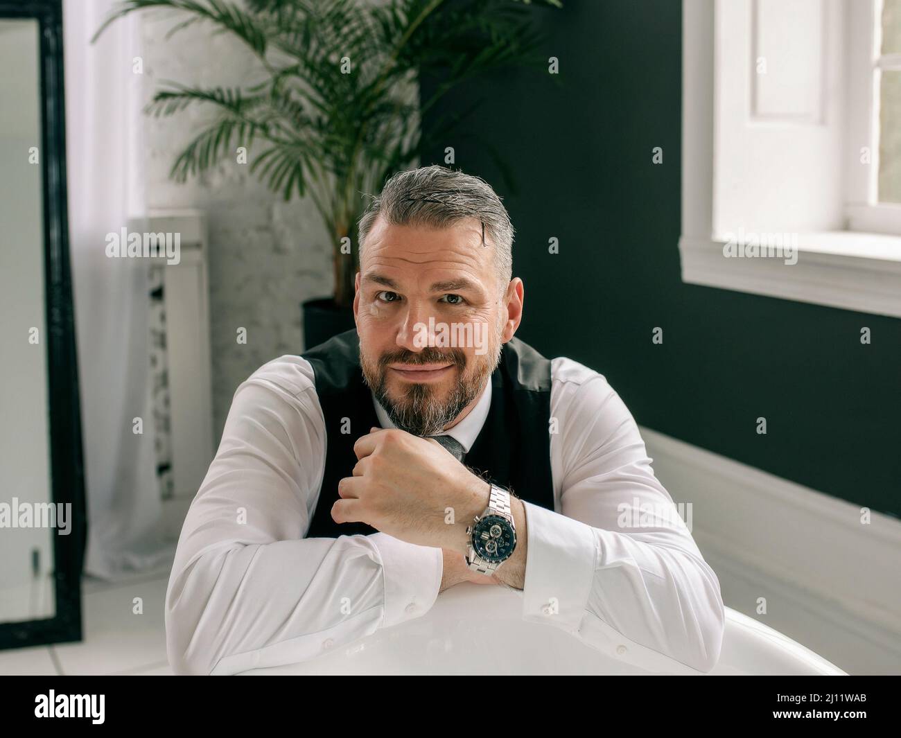 handsome mature courageous  stylish scotsman businessman in kilt and suit in bathroom. Style, work from home, fashion, lifestyle, culture, ethnic Stock Photo