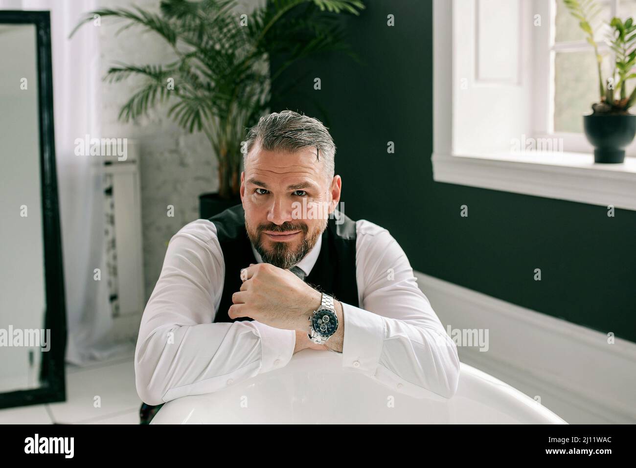 handsome mature courageous  stylish scotsman businessman in kilt and suit in bathroom. Style, work from home, fashion, lifestyle, culture, ethnic Stock Photo