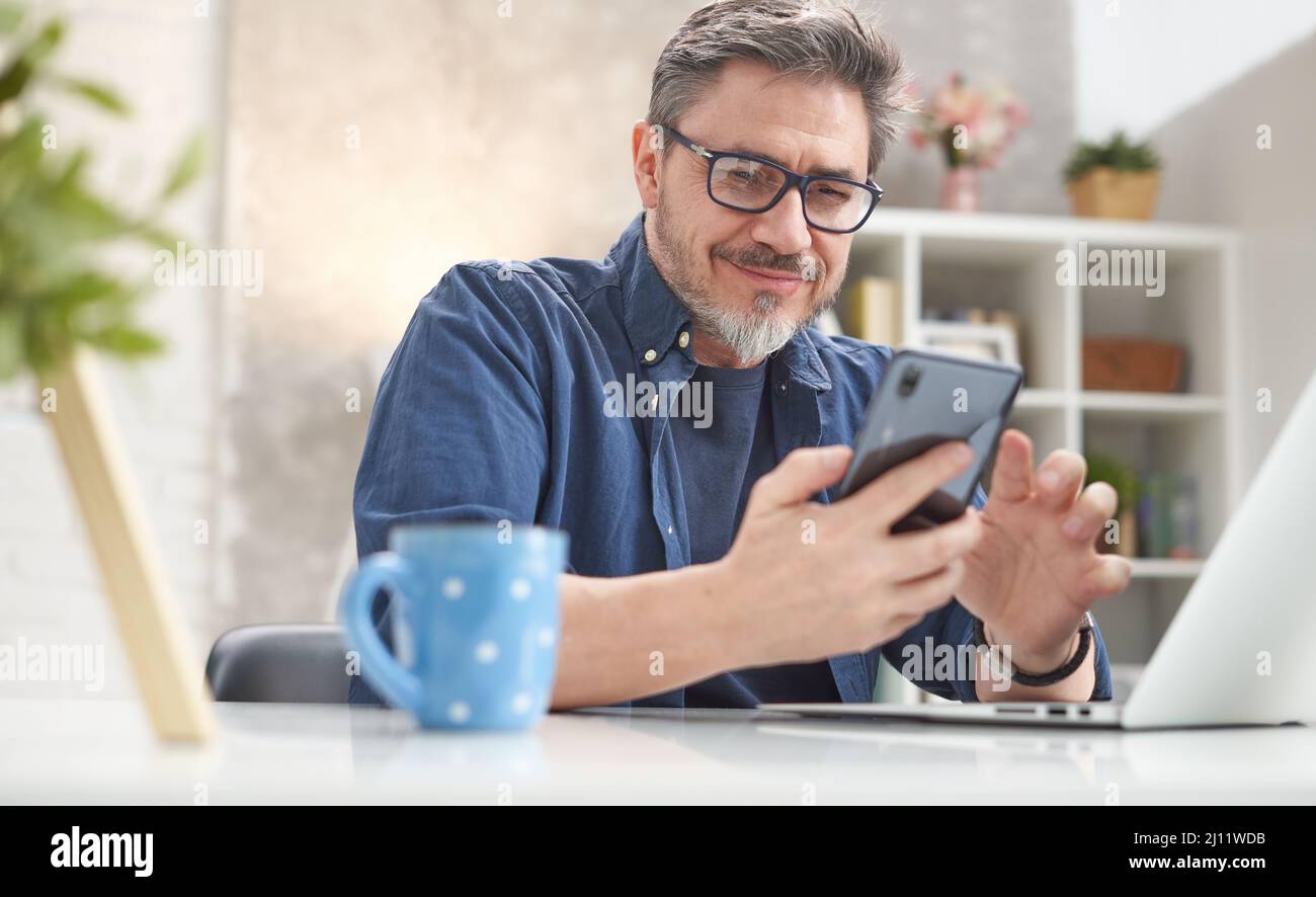 Happy older man using phone hi-res stock photography and images - Alamy