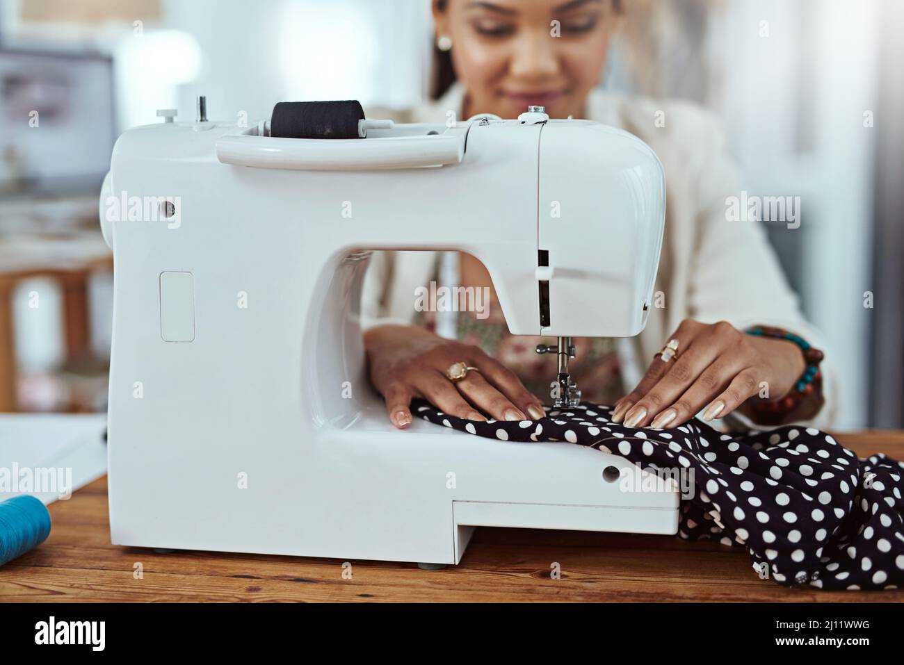 Making a few alterations. Cropped shot of a young fashion designer using a sewing machine in her workshop. Stock Photo