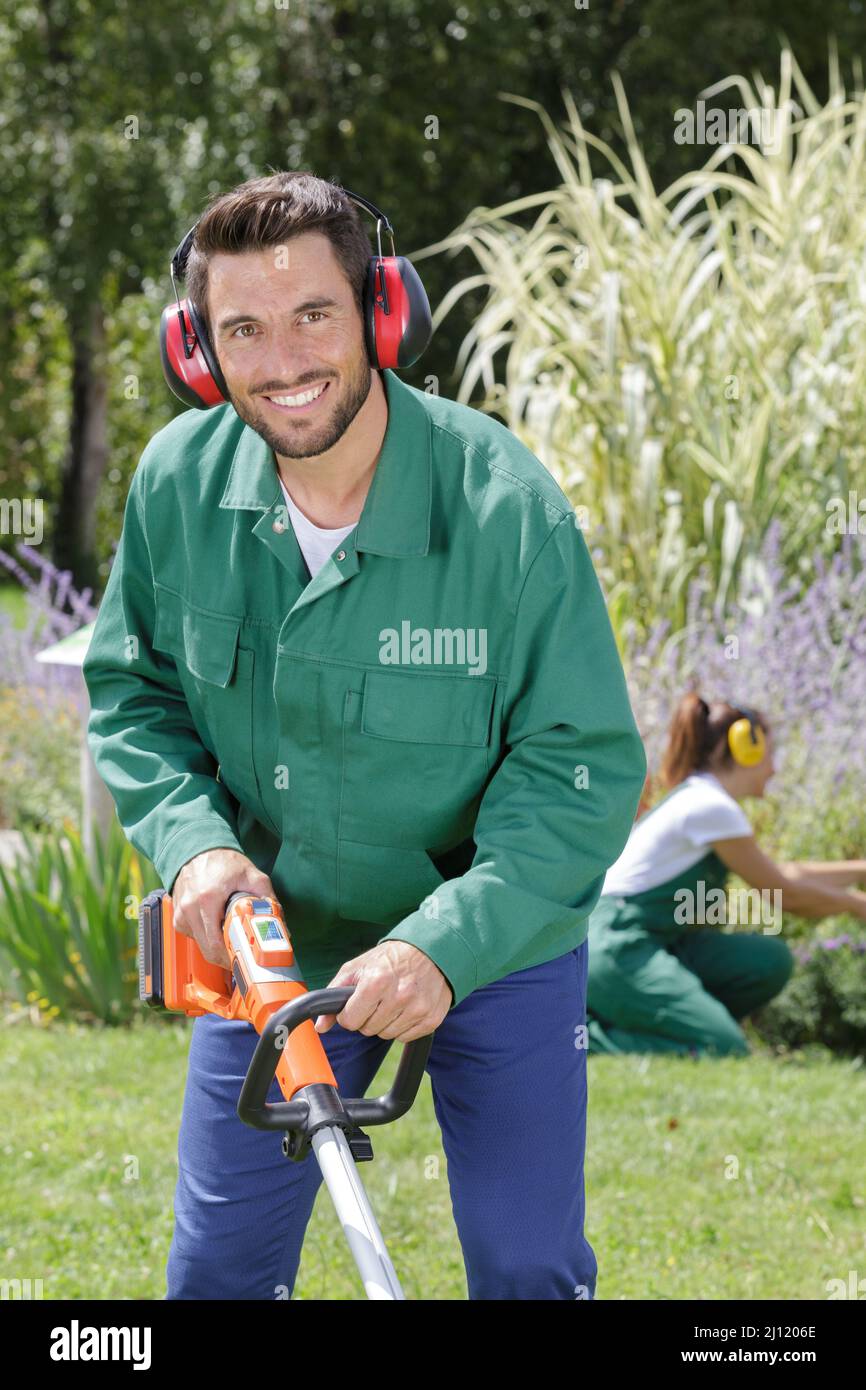 worker using a lawn trimmer mower cutting grass Stock Photo Alamy