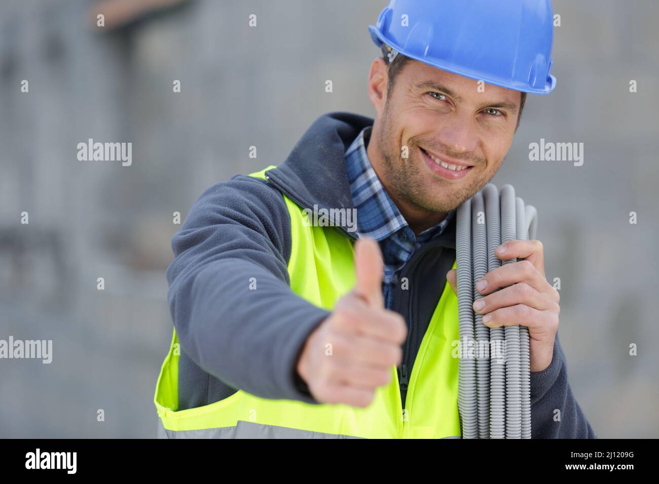 worker with water pipe showing thumb Stock Photo - Alamy