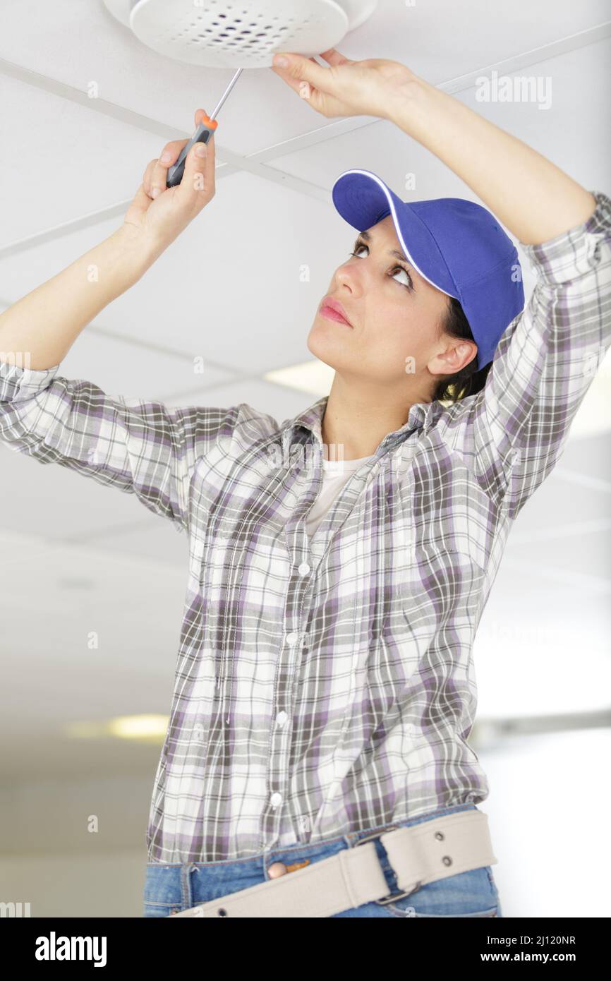 female worker screwing something in the ceiling Stock Photo - Alamy