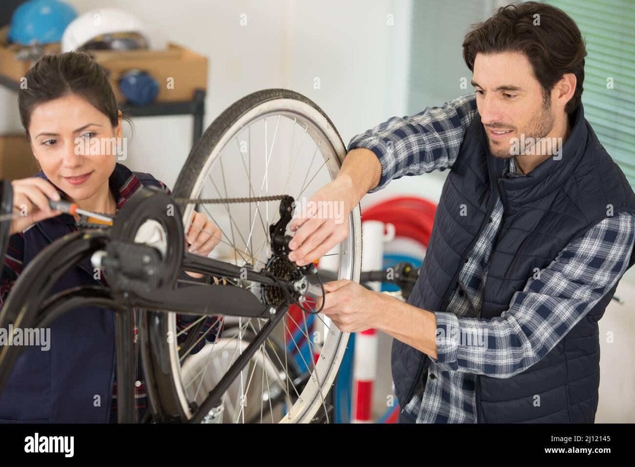 male and female mechanics working on bicycle Stock Photo Alamy