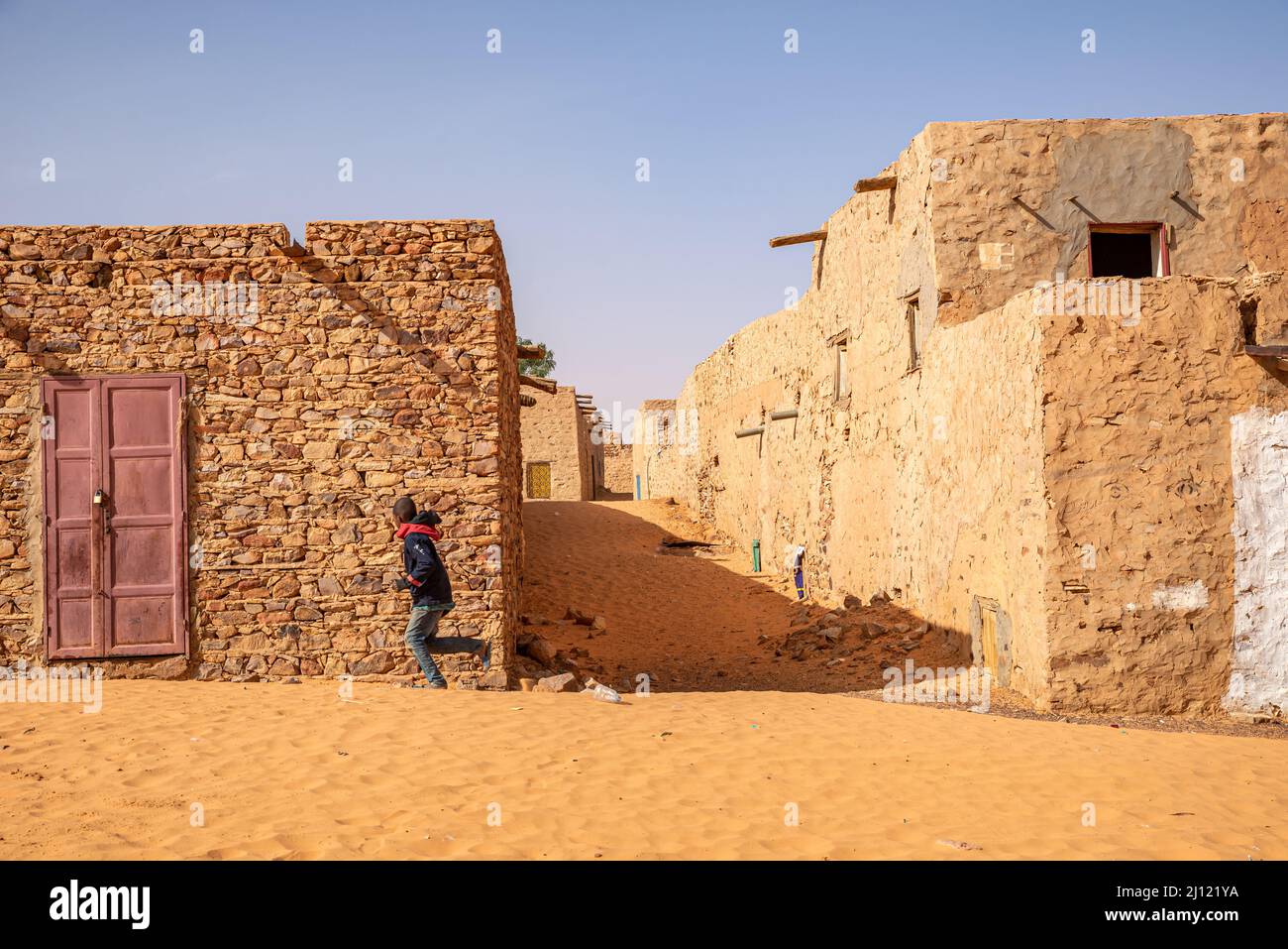 A boy running in the sandy alleys of Chinguetti, Mauritania Stock Photo
