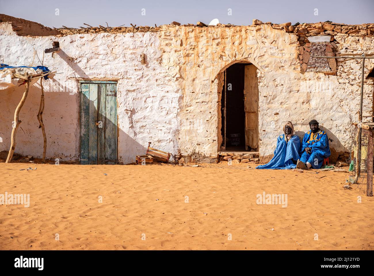 Two adult men in traditional wear sitting in front of a traditional house, Chinguetti, Mauritania Stock Photo