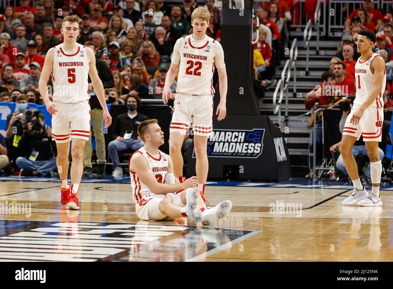 Milwaukee, WI, USA. 20th Mar, 2022. Wisconsin Badgers guard Brad Davison (34) in disbelief after committing a found, while guard Johnny Davis (1), forward Steven Crowl (22), and forward Tyler Wahl (5) come to help him up during the NCAA Men's March Madness Tournament basketball game between the Iowa State Cyclones and the Wisconsin Badgers at the Fiserv Forum in Milwaukee, WI. Darren Lee/CSM/Alamy Live News Stock Photo