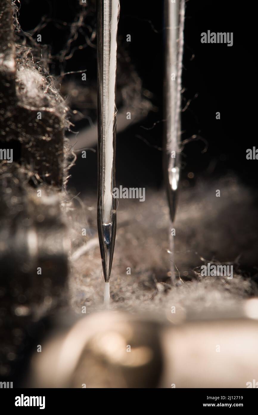 Industrial sewing machine's needles with fibers all around Stock Photo