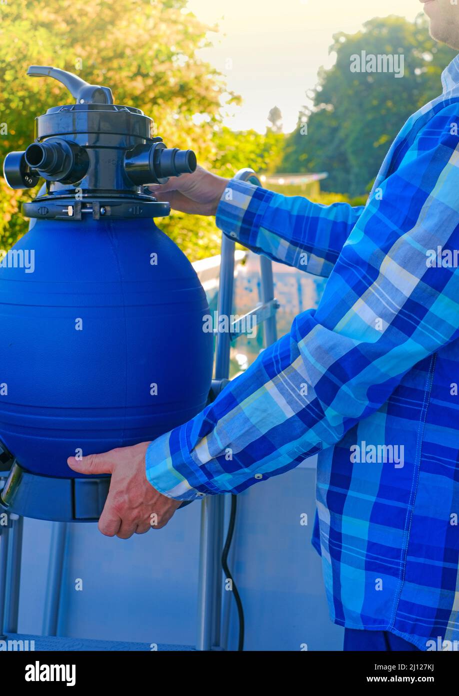 Swimming pool Filter.Swimming pool cleaning equipment. Blue water filter in the hands of a man